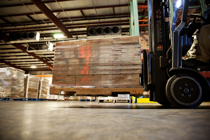 The inside of the Northern Refrigerated Transportation and Poppy State Express warehouse and crossdock, featuring pallets on a forklift.