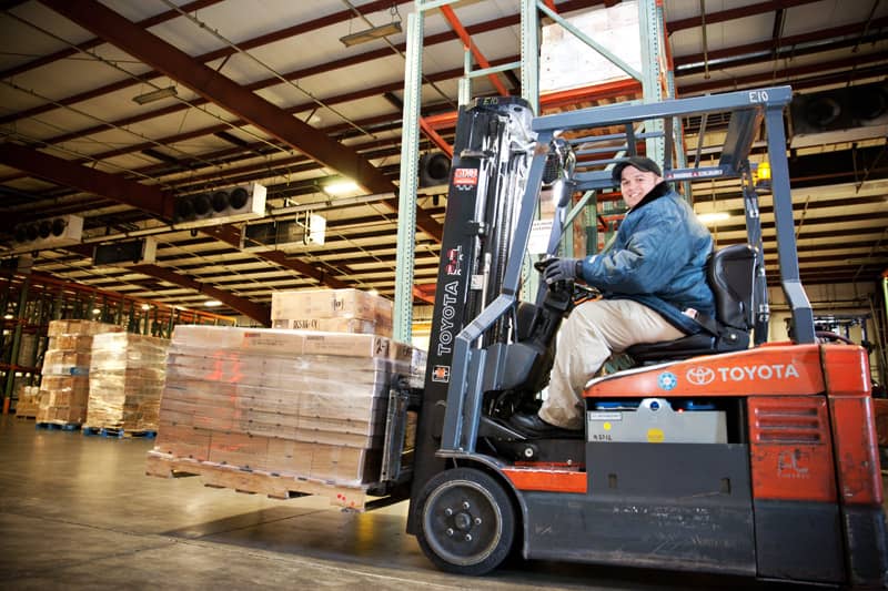 The inside of the Northern Refrigerated Transportation and Poppy State Express warehouse and crossdock, featuring pallets on a forklift. 